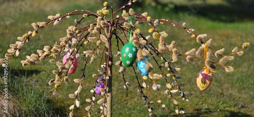 colorful eggs hang from palm branches.
