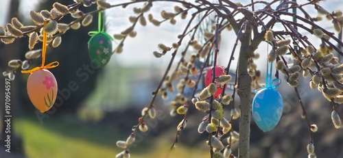 colorful eggs hang from palm branches.