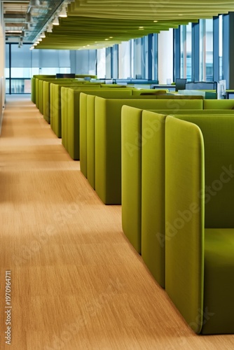 Long line of green booth partitions in modern office
