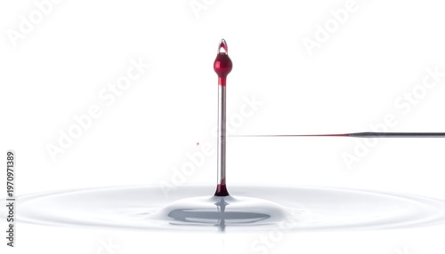 A medical needle suspended mid-air above a pool of liquid. The droplet of red fluid is shaped into a vertical line