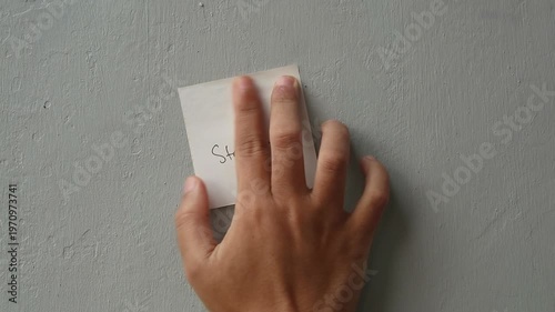Hand placing a sticky note with 