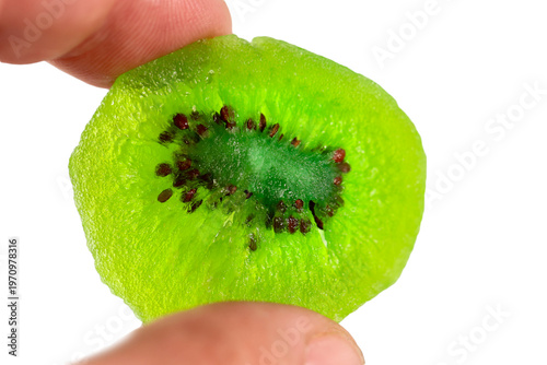 Fresh kiwi fruit slice held between fingers, showcasing vibrant green flesh