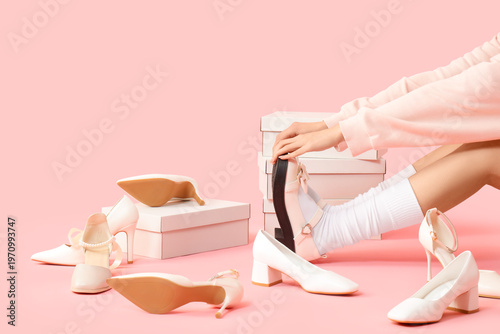 Obraz na plátně Woman with stylish shoes and cardboard boxes on pink background