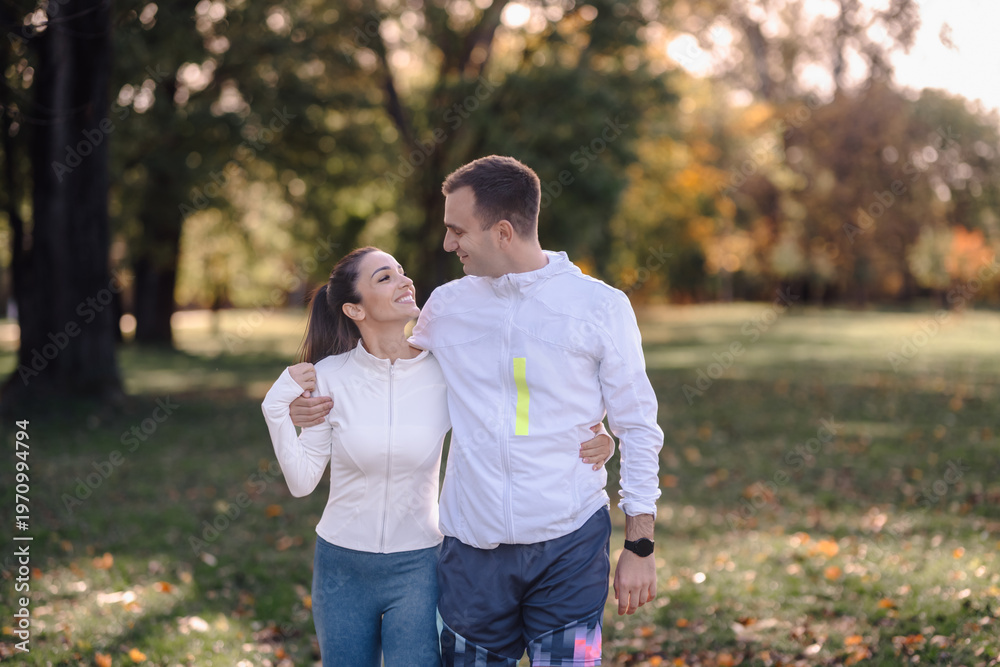 Fototapeta premium Happy couple walking together in park enjoying healthy lifestyle