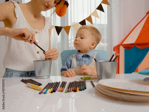 Foto A mother and her young child are engaged in a fun learning activity as they sharpen colored pencils
