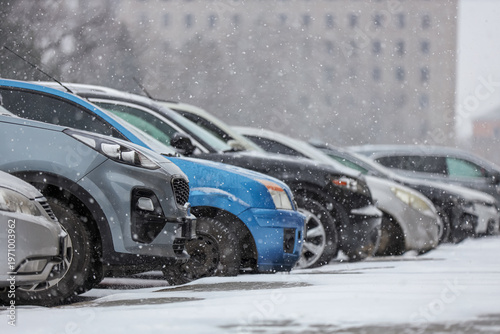 Many cars covered with snow...