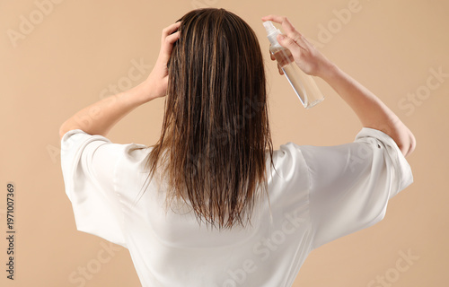 Young woman with hair spray...