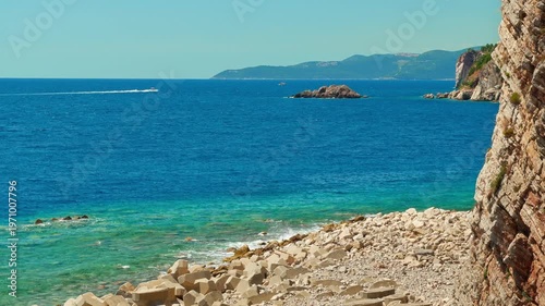 rocky coast of Adriatic Sea, against backdrop of blue water and sky to the horizon, abstract background of summer travel and vacation
