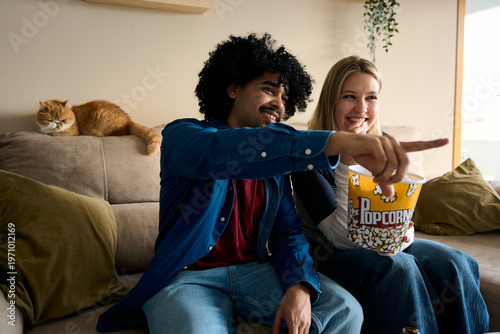 Couple enjoying movie night at home with cat