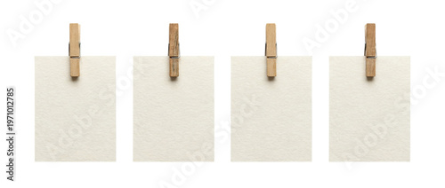 Photos Four blank rectangular watercolor paper tags clipped with wooden clothespins on