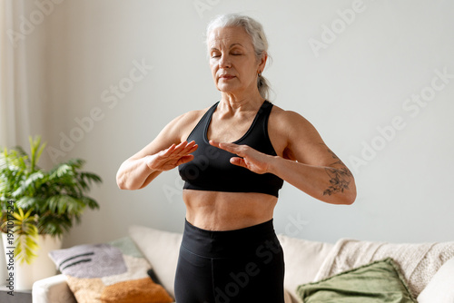 Canvas Print Senior woman meditating at home, practicing mindfulness and a healthy lifestyle