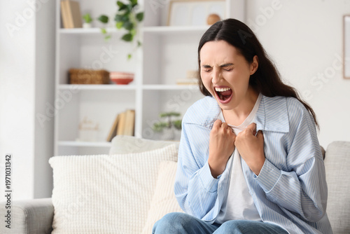 Screaming young woman sitti...