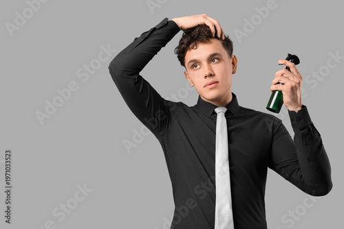 Handsome young man spraying...