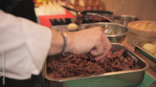 Chef’s hands marinating meat
