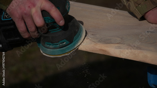Foto Sanding wood with a vibrating machine