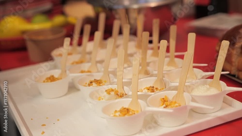 Chef’s hands adding hazelnuts on vanilla ice cream