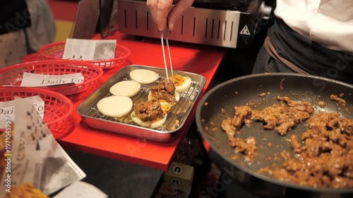 Close-up of a chef’s hands preparing meat bao buns
