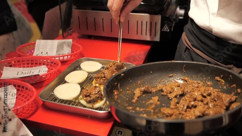 Close-up of a chef’s hands preparing meat bao buns