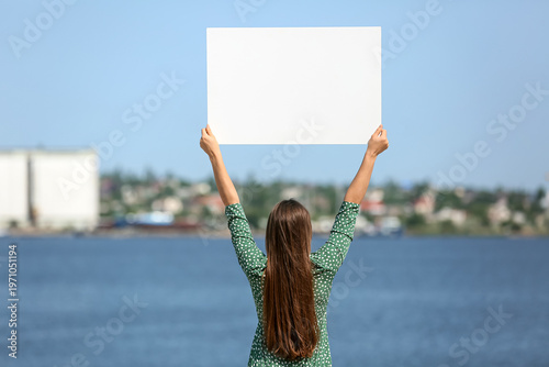 Young woman holding blank p...