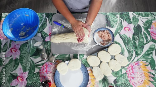 A woman rolls out a pancake of dough in her hands for a future pie. High quality 4k footage