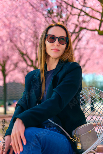 girl walks through a park with flowering trees