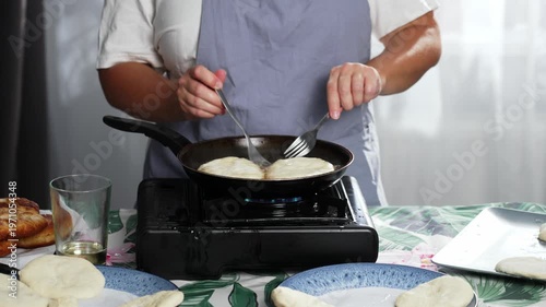 Carefully, with two forks, the woman turns the meat pies over to ensure even cooking. High quality 4k footage