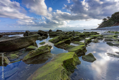 Slika na platnu Serene landscape of mossy rocks and glassy water reflections at Blue Stone Beach
