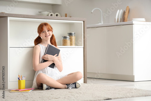 Little redhead girl with ta...