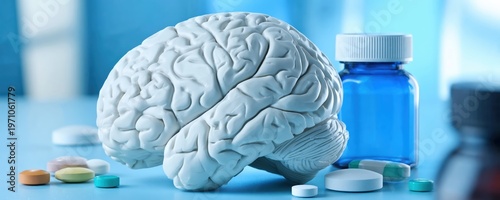 A model of a human brain with scattered pills and a blue medicine bottle, symbolizing brain health, neurology, and pharmaceutical treatment.
