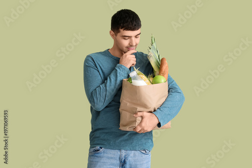 Young man with grocery bag ...