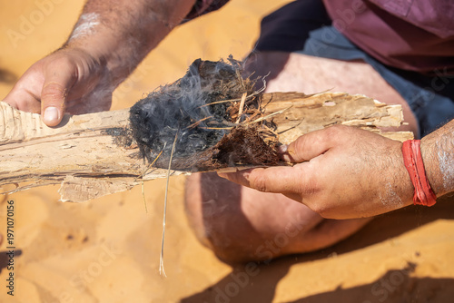 Traditional fire making by friction using wooden sticks in Australian indigenous survival practice