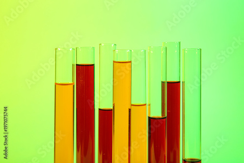 Test tubes with different samples on colorful background, closeup
