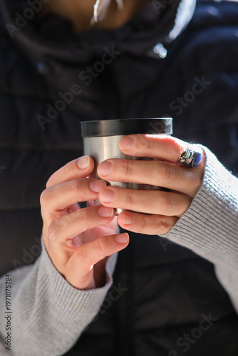 close-up of a thermos cup in his hands