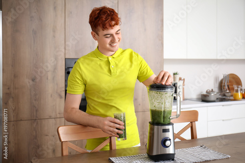 Young man making green smoo...