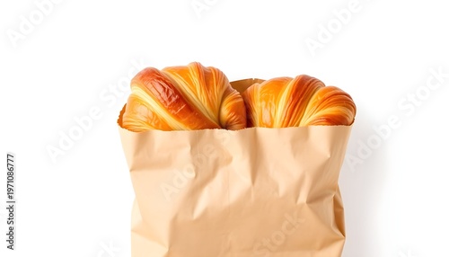 Golden croissants peeking out of a brown paper bag on a white table