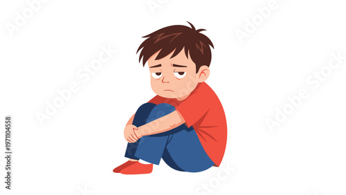 Sad and lonely little boy sits on the floor, hugging his knees, depicting feelings of sadness or depression.