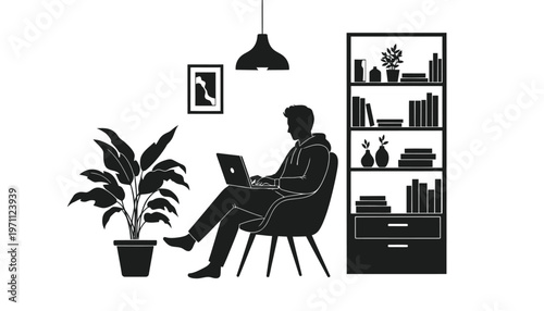 Silhouette of a man sitting in an armchair while working on his laptop at home