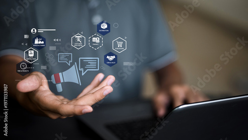 Businessman holding virtual megaphone with omnichannel marketing and ERP business management icons.