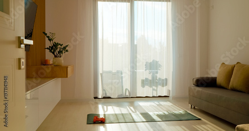 Schilderij op canvas In a tranquil living room bathed in morning sunlight, a sports mat and dumbbells sit ready for an invigorating workout