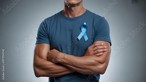 Man wearing blue t shirt with light blue awareness ribbon pinned