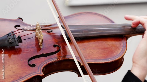 Learning to play the violin with close up shots of hands on strings and bowing technique in a practice session