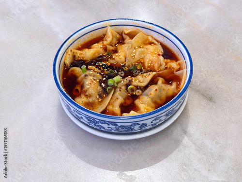 steam hong you dumpling Xiao long bao Shanghai small meat wanton in bowl with mala spicy chilli vinegar on white marble table dim sum halal food breakfast menu for china Hong Kong cafe