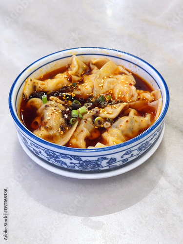 steam hong you dumpling Xiao long bao Shanghai small meat wanton in bowl with mala spicy chilli vinegar on white marble table dim sum halal food breakfast menu for china Hong Kong cafe