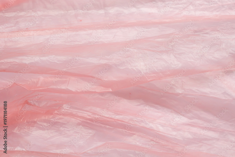 Fototapeta premium Crumpled red plastic texture, wrinkled polyethylene bag surface background