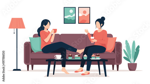 Two female friends relax on a sofa in a living room enjoying coffee, cupcakes, and a pleasant conversation together in a cozy home.