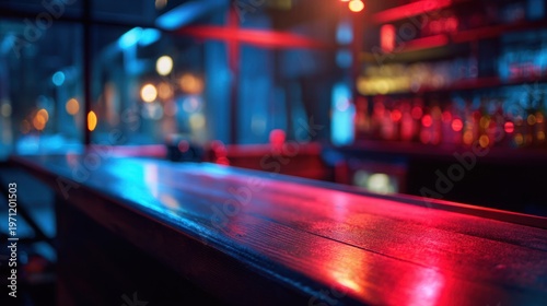 An empty bar top illuminated by vibrant red and blue neon lights, creating a colorful and moody atmosphere in a nightlife setting