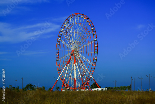Red Ferris wheel in a blue sky.