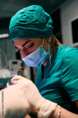 Focused medical professional in surgical scrubs and mask performing a precise dental procedure in clinic
