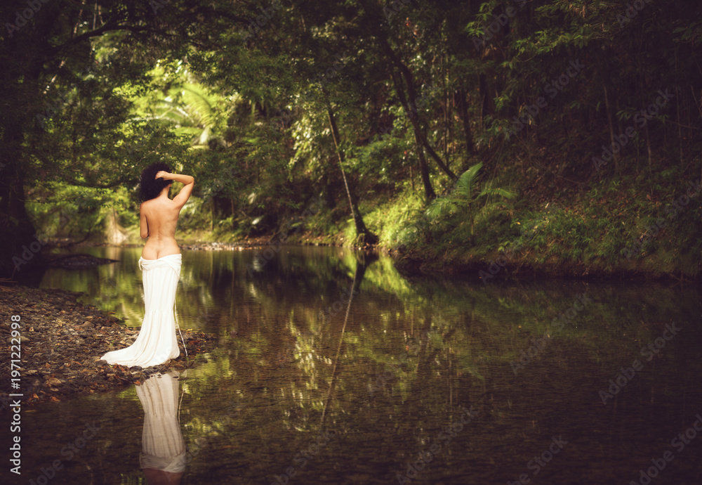 Fototapeta premium tropical rainforest creek scenes featuring an elegant woman with curly hair in a white dress , together with serene reflective landscapes surrounded by lush green forest and soft natural light.