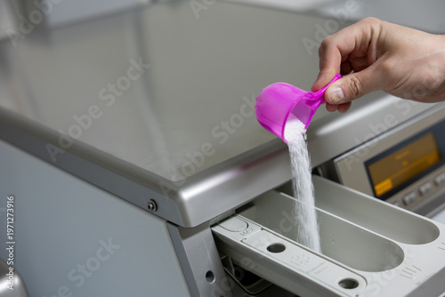 man putting a washing machine to washing machine